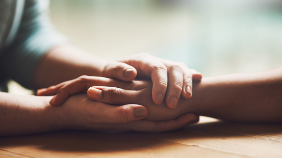 Två personer som håller om varandras händer. Foto: Mostphotos.