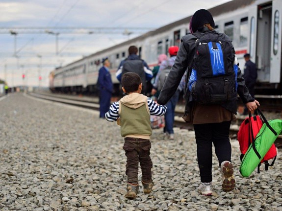 flyktingar som går vid ett tåg. Foto:Mostphotos