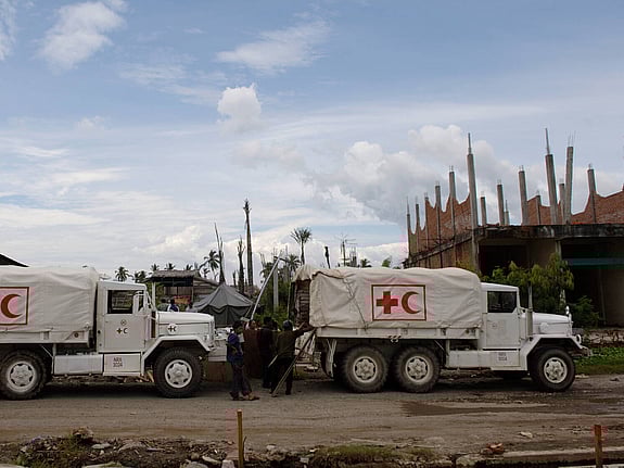 Two trucks marked with The Red Cross